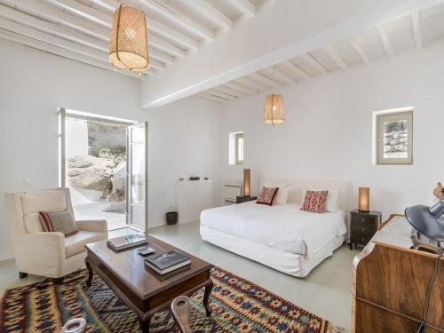 a bedroom with a bed and a couch and a table at Traditional villa with swimming pool in Ano Mera