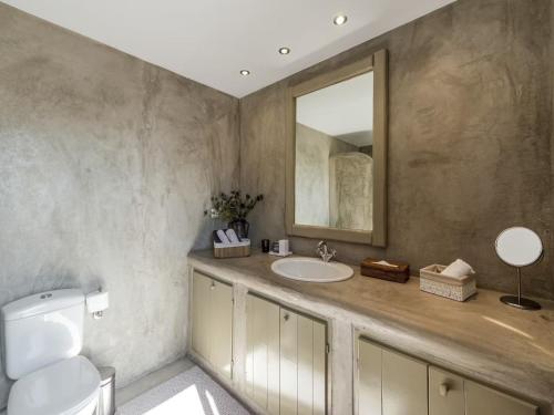 a bathroom with a sink and a mirror at Traditional villa with swimming pool in Ano Mera