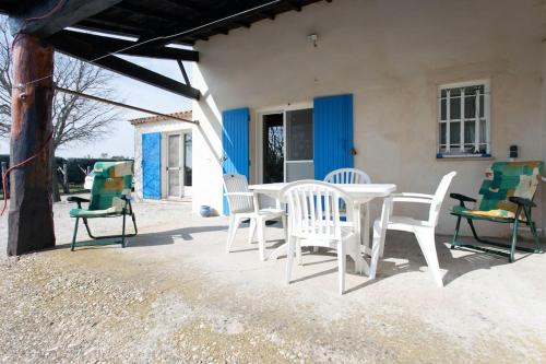 une table blanche et des chaises sur une terrasse dans l'établissement Country house in Arles Provence peaceful and lovely, à Arles