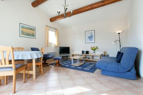 un salon avec un canapé bleu et une table dans l'établissement Country house in Arles Provence peaceful and lovely, à Arles