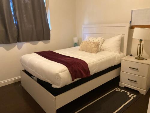 a small bedroom with a white bed and a nightstand at Three bedrooms apartment in Salt Lake City