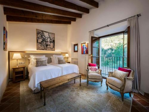 a bedroom with a bed and a large window at Traditional villa with private pool in Banyalbufar