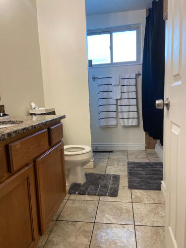 a bathroom with a toilet and a window at Three bedrooms apartment in Salt Lake City