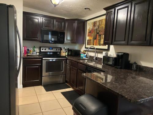 eine Küche mit Holzschränken und einer Arbeitsplatte in der Unterkunft Three bedrooms apartment in Salt Lake City