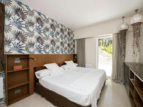 a bedroom with a large bed and a large window at Villa in Es Cubells with Infinity Pool & Views in San Jose