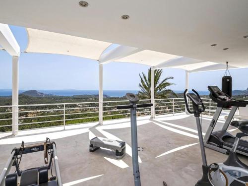a gym with a view of the ocean at Villa in Es Cubells with Infinity Pool & Views in San Jose