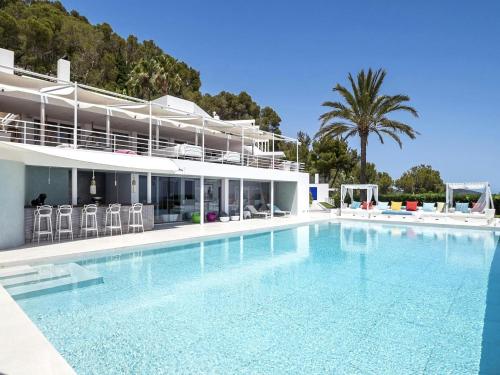 a large swimming pool in front of a building at Villa in Es Cubells with Infinity Pool & Views in San Jose