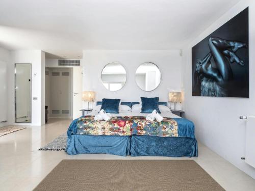 a bedroom with a large bed and two mirrors at Villa in Es Cubells with Infinity Pool & Views in San Jose