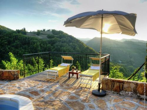 a patio with two chairs and an umbrella at Scenic holiday home in Modigliana with fenced garden in Modigliana