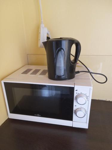 a black pot sitting on top of a microwave at FAMILY ROOM lux in Brussels