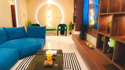 a living room with a blue couch and a tv at USMANS 3 Bedroom Apartment all Rooms Sea View Direct Beach Access Daily HOUSEKEEPING JBR in Dubai