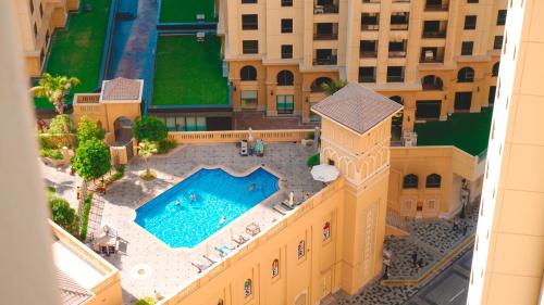 an aerial view of a building with a swimming pool at USMANS 3 Bedroom Apartment all Rooms Sea View Direct Beach Access Daily HOUSEKEEPING JBR in Dubai