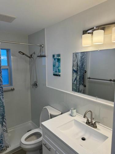 a white bathroom with a sink and a toilet at Seashell 5 in Boynton Beach
