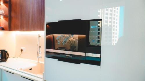 a kitchen with a tv on a wall at USMANS 3 Bedroom Apartment all Rooms Sea View Direct Beach Access Daily HOUSEKEEPING JBR in Dubai