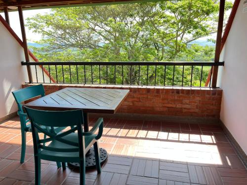 a porch with a wooden table and chairs on a balcony at Hotel Los Viñedos in Lemos
