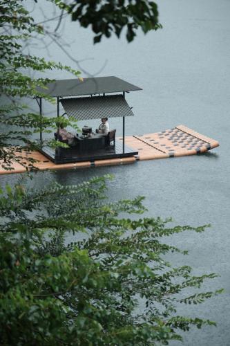 a pavilion on the water with two people on it at Yakamoz Qianchuan Hotel in Lin'an