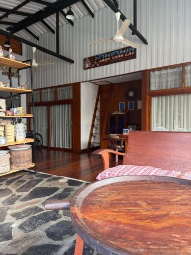 a living room with a wooden table and a dining room at Baan Chan Lay Koh Chang in Ko Chang