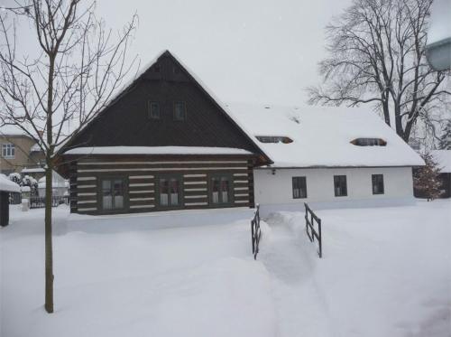 a log cabin with snow on the ground at Penzion Betlém in Hlinsko