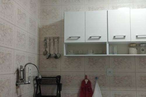 une cuisine avec des armoires blanches et un évier dans l'établissement Apartamento ACOLHEDOR, à Rio de Janeiro