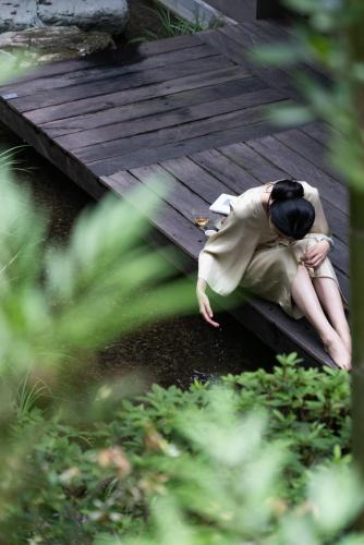 a man laying on a wooden walkway at Yakamoz Qianchuan Hotel in Lin'an
