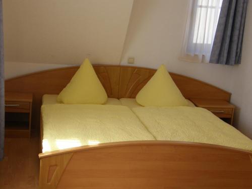 a bedroom with a bed with yellow pillows on it at Hotel Pension zu Dresden Altpieschen in Dresden