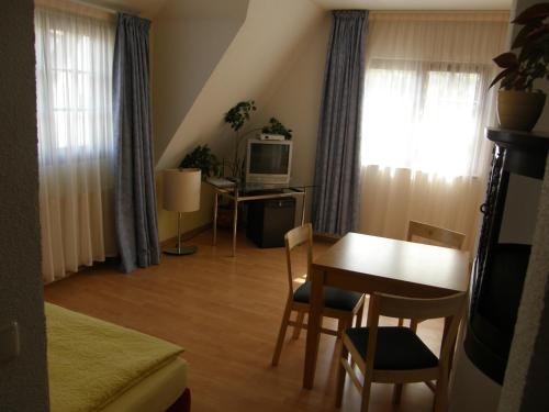 ein Wohnzimmer mit einem Tisch und einem Esszimmer in der Unterkunft Hotel Pension zu Dresden Altpieschen in Dresden