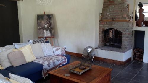a living room with a couch and a fireplace at A Hilltop Country Retreat in Swellendam