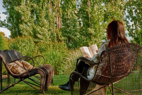 a woman sitting on a park bench reading a book at mirabosque new aparments 4 in Osorno