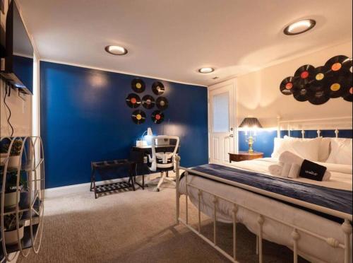 a bedroom with a blue wall with a bed and a desk at Bloomingdale Blues Speakeasy Free Parking in Washington, D.C.