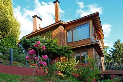 a wooden house with flowers in front of it at mirabosque new aparments 4 in Osorno