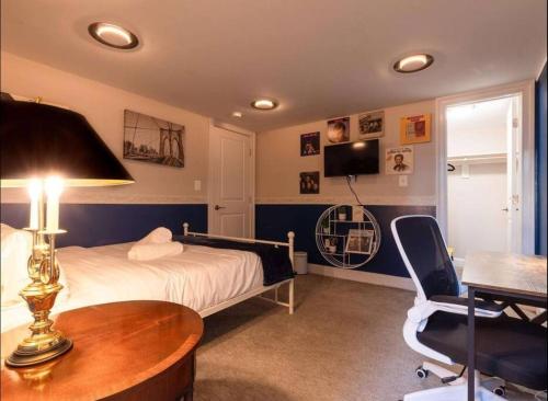 a bedroom with a bed and a table and a chair at Bloomingdale Blues Speakeasy Free Parking in Washington, D.C.
