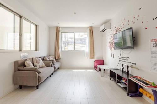 a living room with a couch and a tv at 山手線田端駅から徒歩5分、とても便利な場所です in Tokyo