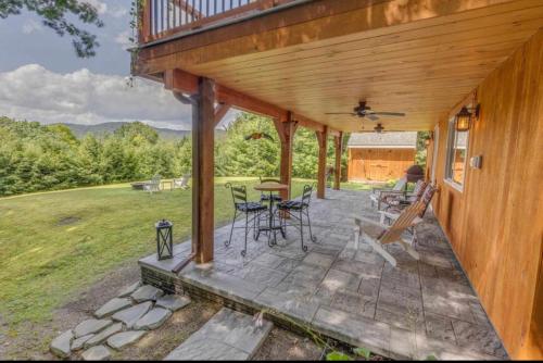 a porch of a house with a table and chairs at Waterville Wonderland in Thornton