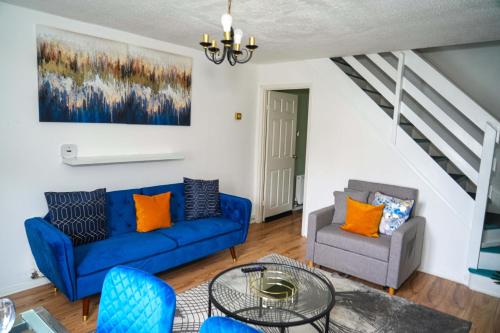 a living room with a blue couch and a chair at Milton Keynes Home - Sleeps 4 - Parking in Milton Keynes