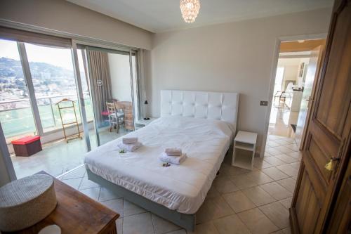 - une chambre avec un lit blanc et un balcon dans l'établissement Central Park by Connexion, à Cannes