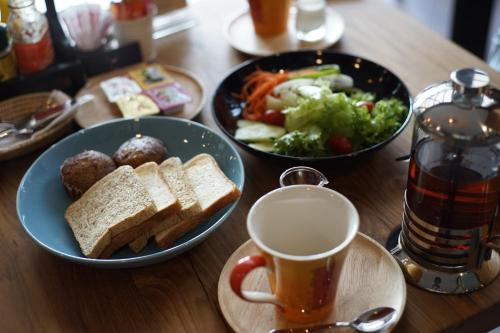 a table with two bowls of food and a cup of coffee at Cmor by Recall Hotels SHA Extra Plus in Chiang Mai