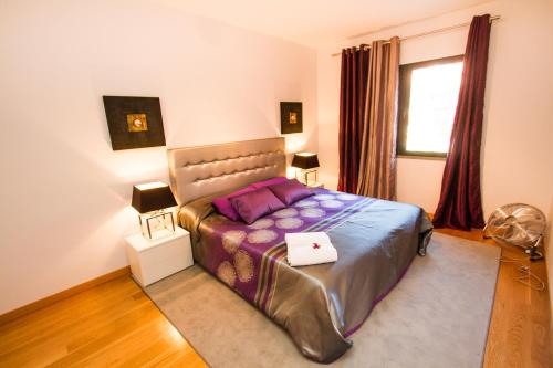 フンシャルにあるマデリア ラグジュアリー ヴィラ リビング フンシャルのベッドルーム1室(大型ベッド1台、紫色の枕付)
