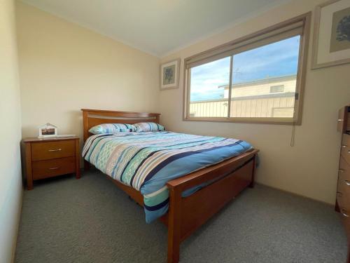 Un dormitorio pequeño con una cama y una ventana. en Marine Escape, en Cape Paterson