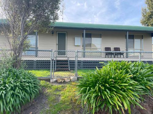 una casa con dos sillas delante en Marine Escape, en Cape Paterson