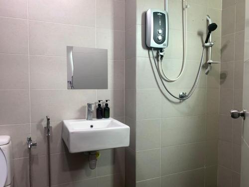 a bathroom with a sink and a shower with a mirror at d'Tempat Country Club, Hijayu 3d, Terrace House in Siliau