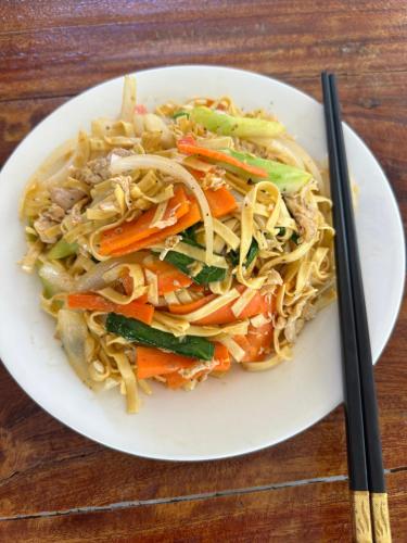 a white plate of food with noodles and vegetables at David Hostel in Koh Rong