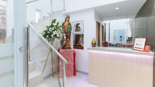 a red door store with a statue on the counter at RedDoorz @ St. Catherine Residences Olongapo City in Olongapo