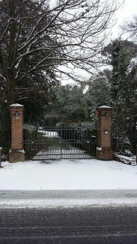 a gate with a fence with snow on the ground at Villa Mainardi Agriturismo in Camino al Tagliamento