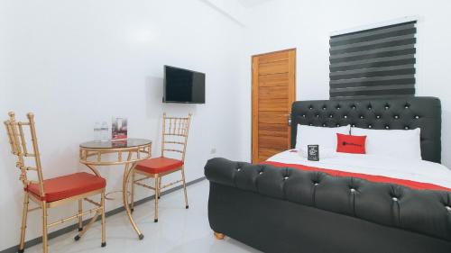 a bedroom with a bed and a table and a chair at RedDoorz @ St. Catherine Residences Olongapo City in Olongapo