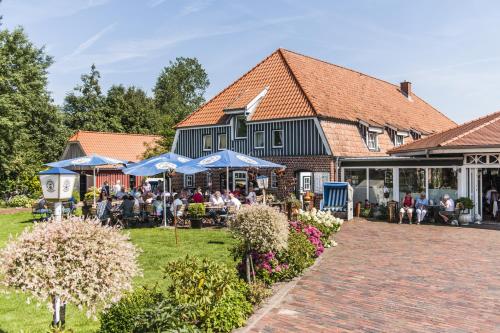 a group of people sitting at tables outside of a building at Hotel Fauna in Breiholz