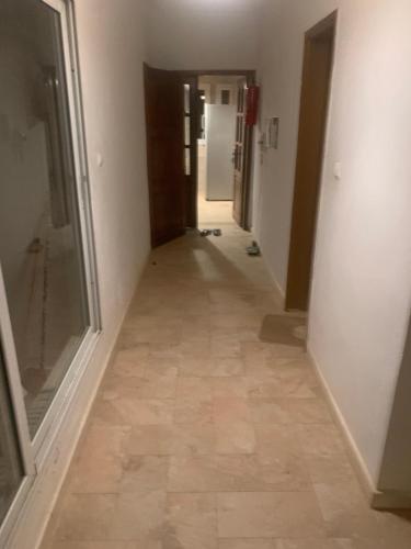 korytarz z podłogą wyłożoną płytkami w budynku w obiekcie Chambre salon w mieście Dakar