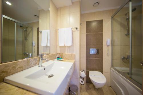 uma casa de banho com um lavatório, um WC e um chuveiro em Eldar Resort Hotel em Kemer