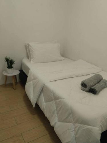 a white bed with two towels on top of it at ITCC Manhattan Suites by Kansayan Homestay in Penampang