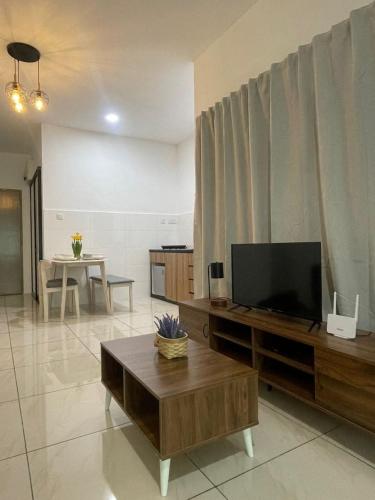 a living room with a television and a table at ITCC Manhattan Suites by Kansayan Homestay in Penampang
