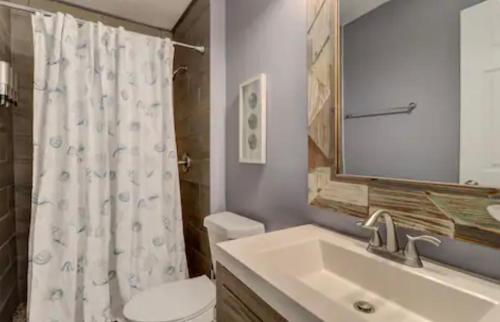 a bathroom with a sink and a toilet and a mirror at #88 Elegant 3-Bedroom Pet Friendly with Parking in Hilton Head Island